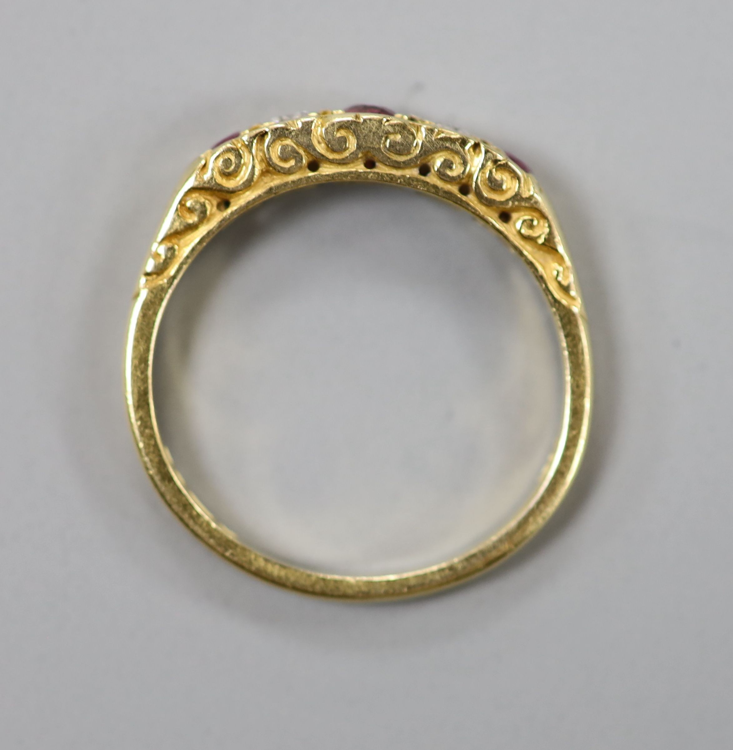 A modern 18ct gold, two stone diamond and three stone ruby half hoop ring, size O, gross weight 3.8 grams.